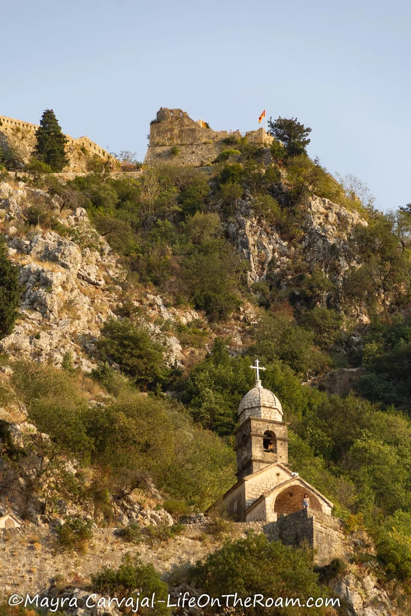 An old small church up in the mountain with a dome and a cross