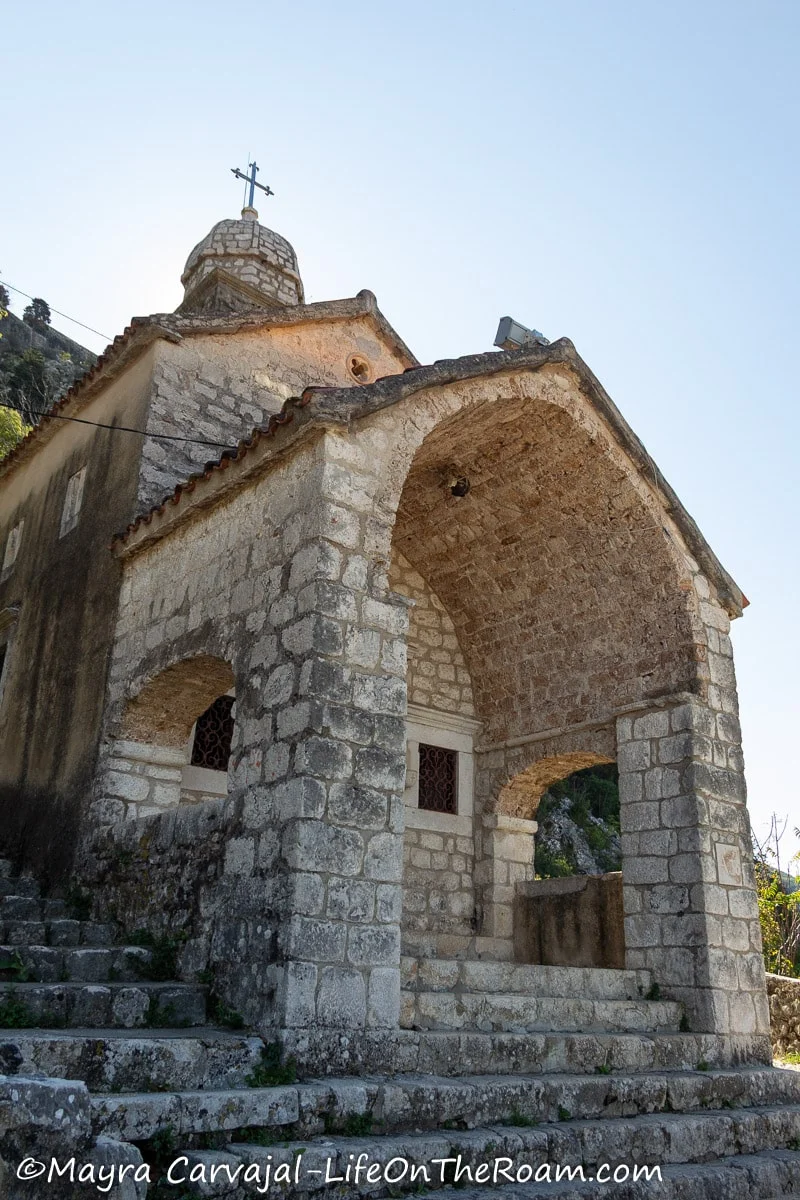 An old stone church with an arch in the portico