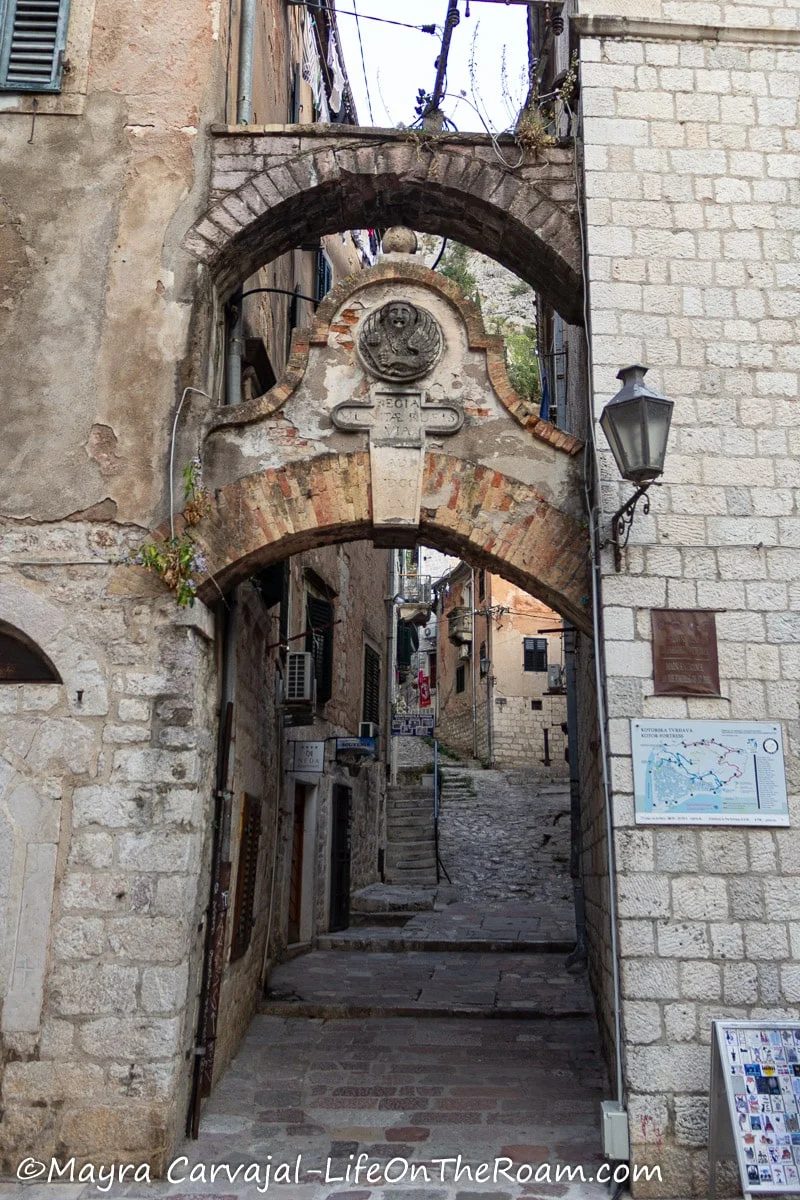Entrance of an alleyway with an arch on top with the Lion of St Mark