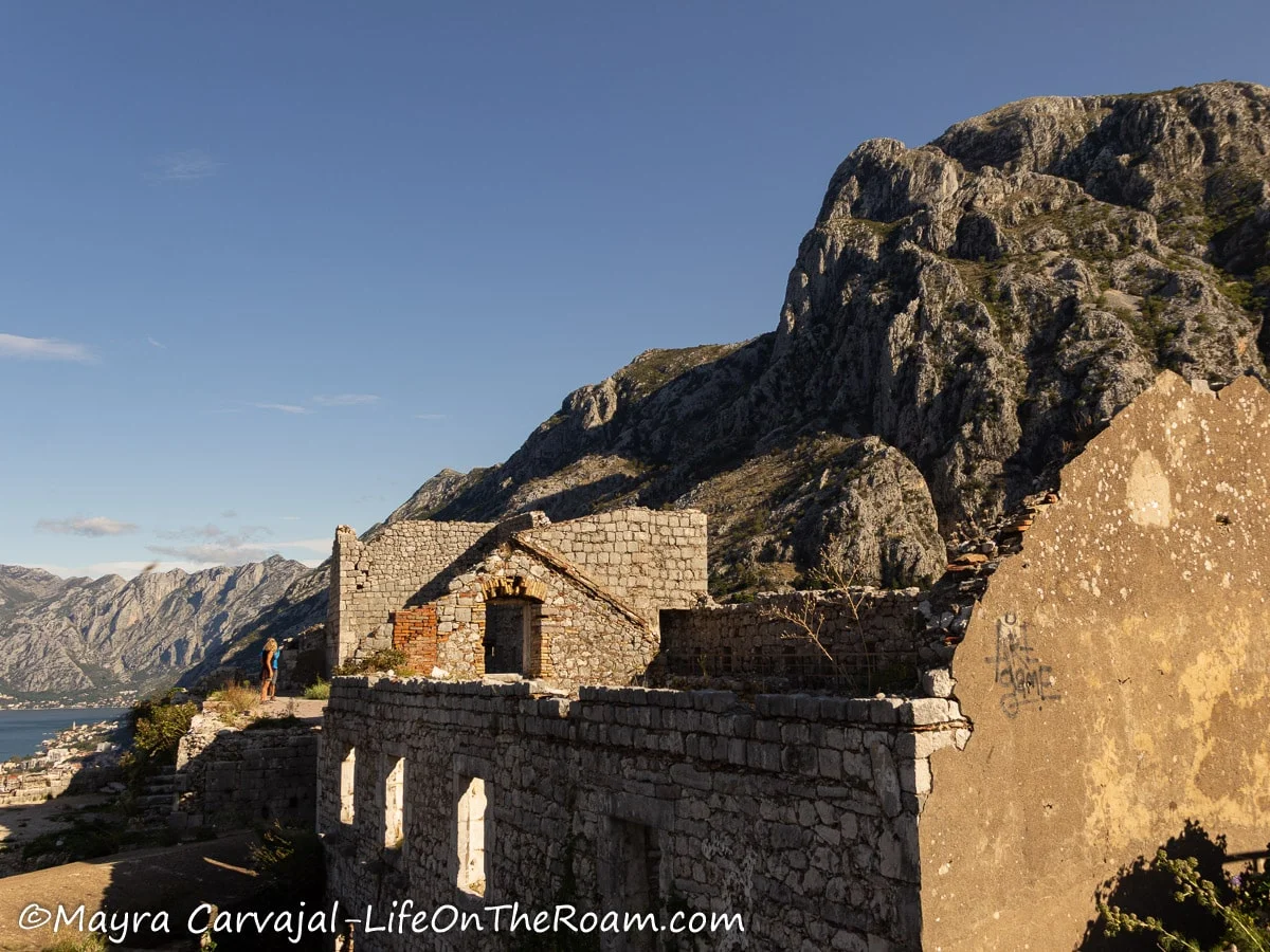 Ruins of a former fortress with a collapsed roof with a mountain in the background