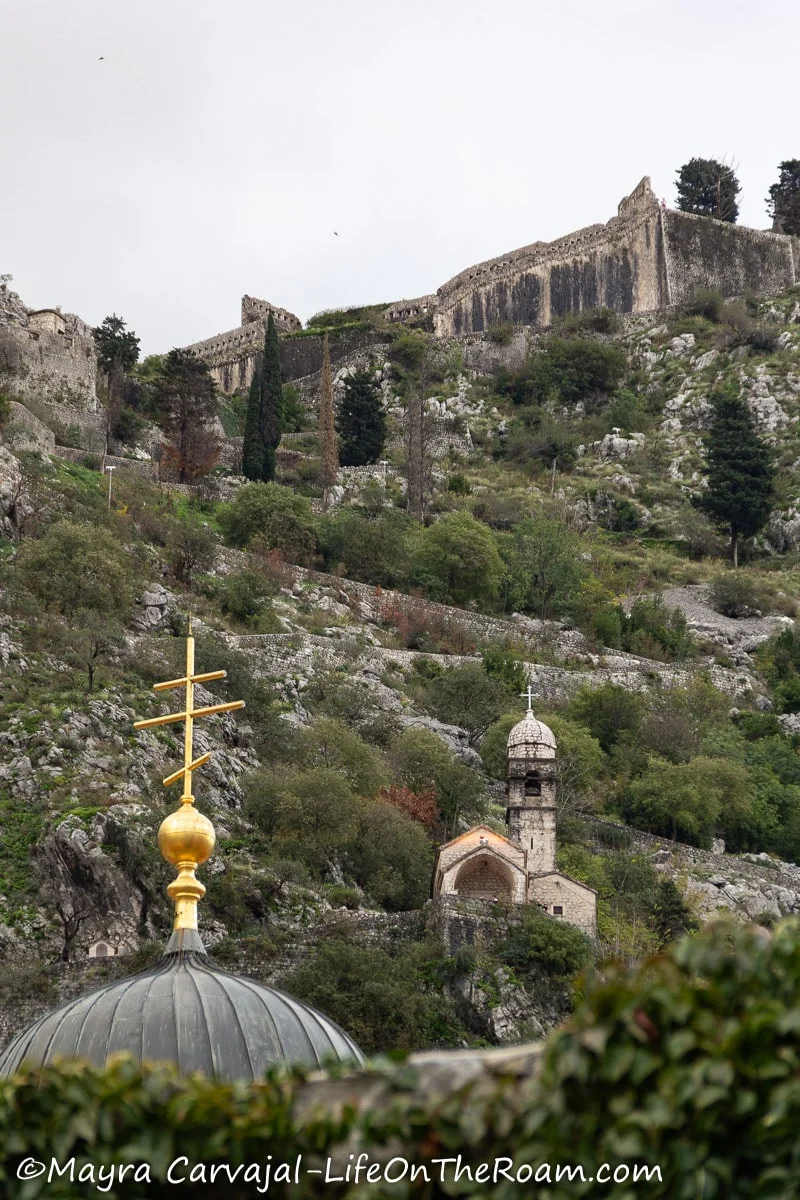 View of an ancient church and a trail towards fortified walls in a mountain