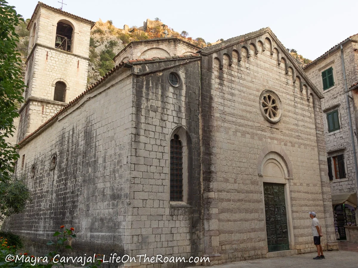 An ancient church with a bronze door and a rose window