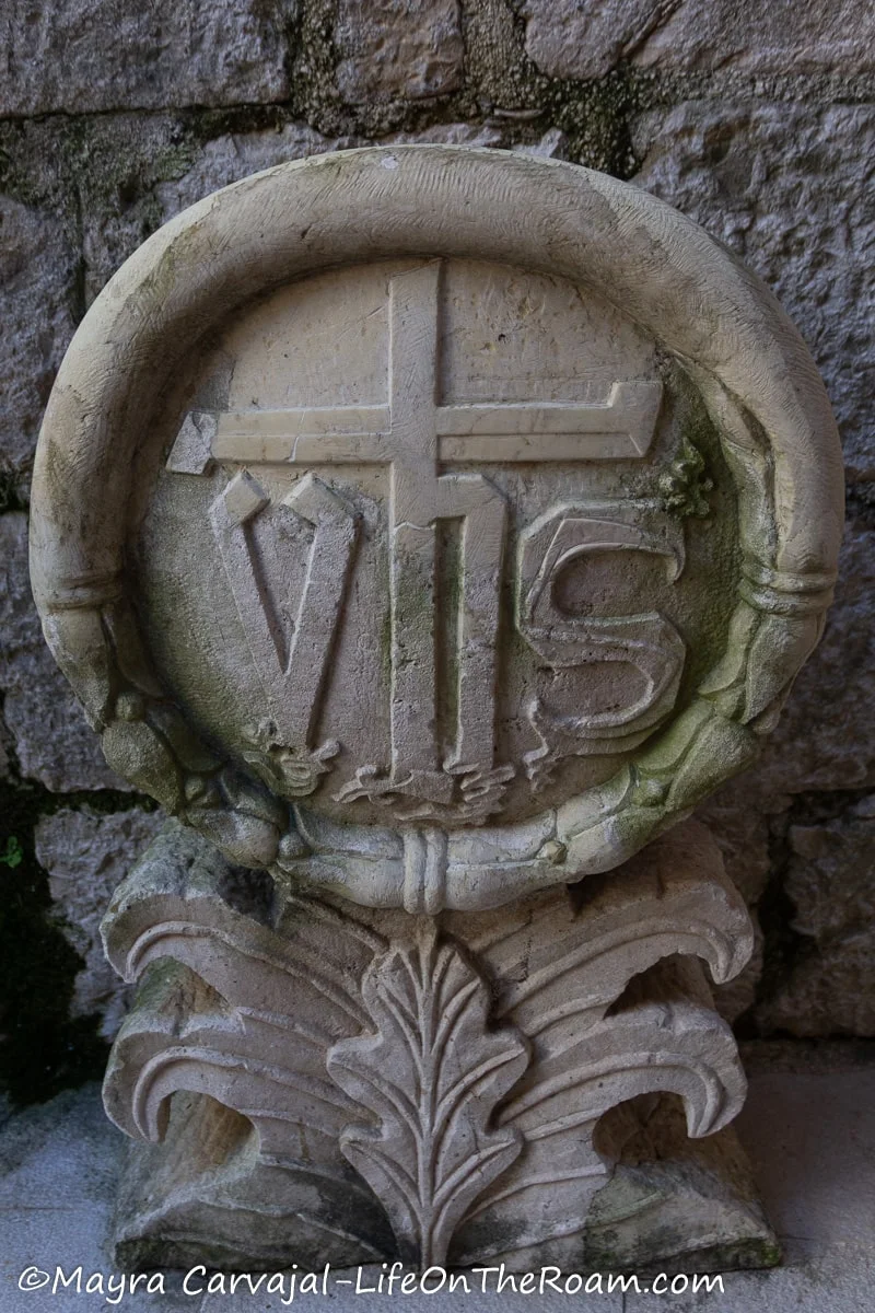 An architectural ornament in stone with the letters vhs