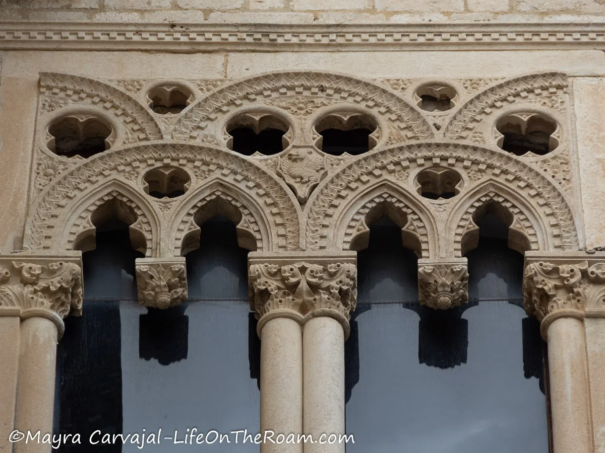 A window with Gothic-period details like pointy arches and quatrefoils