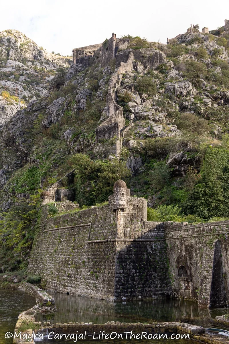 A defensive wall along a river, going up on a hill