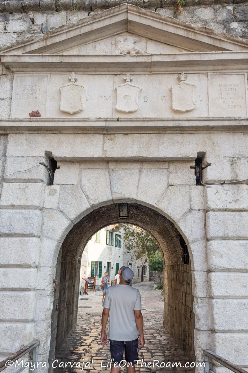 A man crossing an arched gate built in medieval times