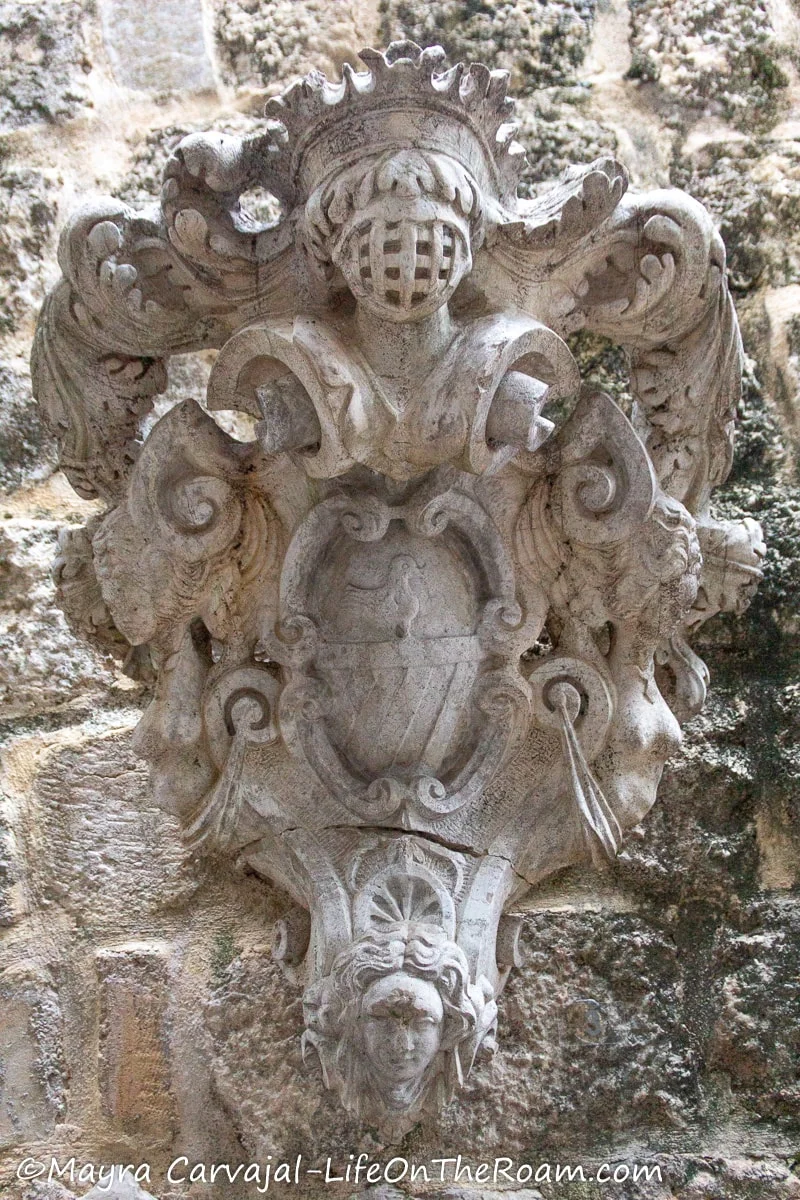 An architectural ornament with swirls and a feminine figures