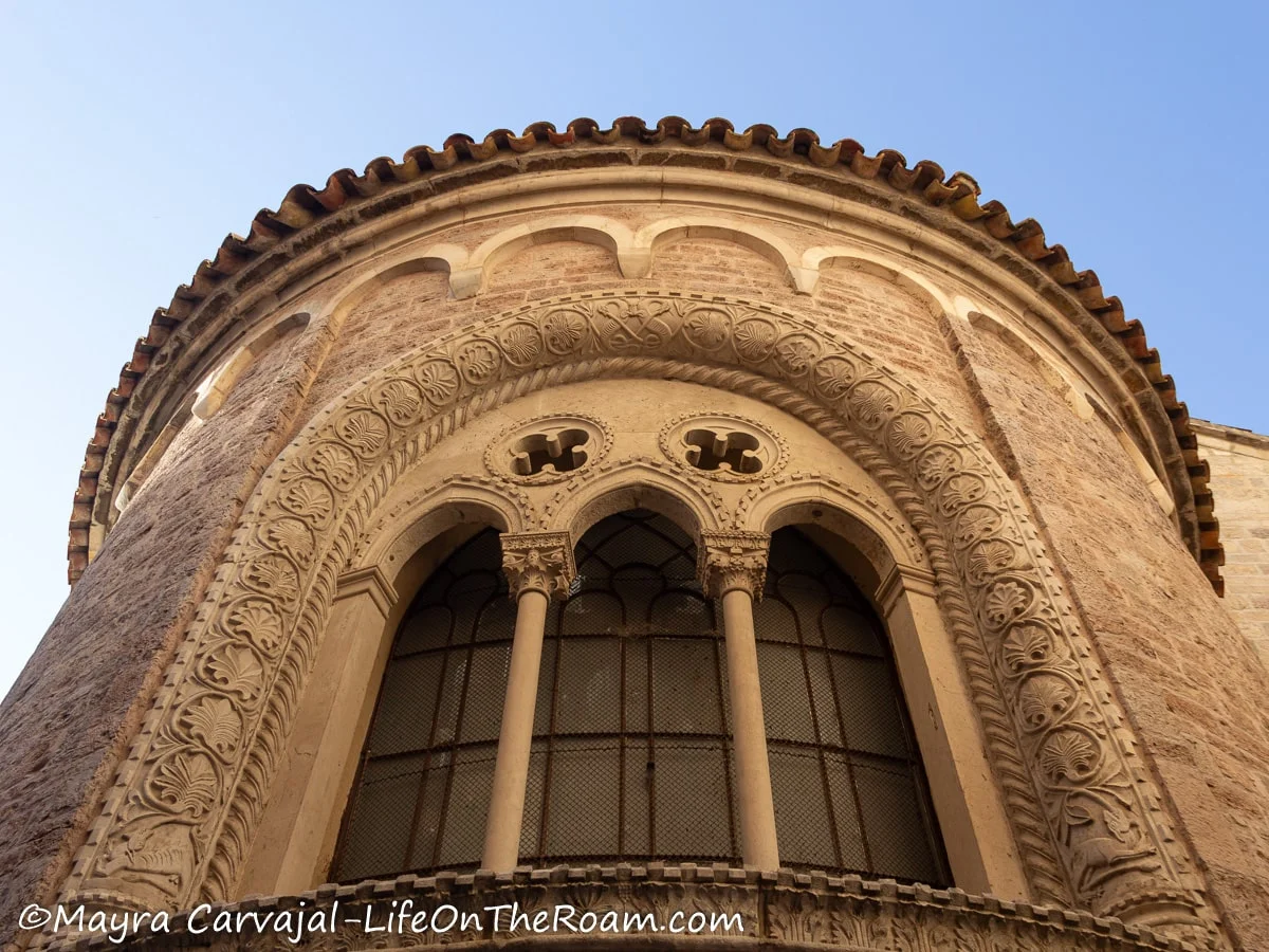 An arched window with three pointy inner arches and two quatrefoils, with an elaborate trim