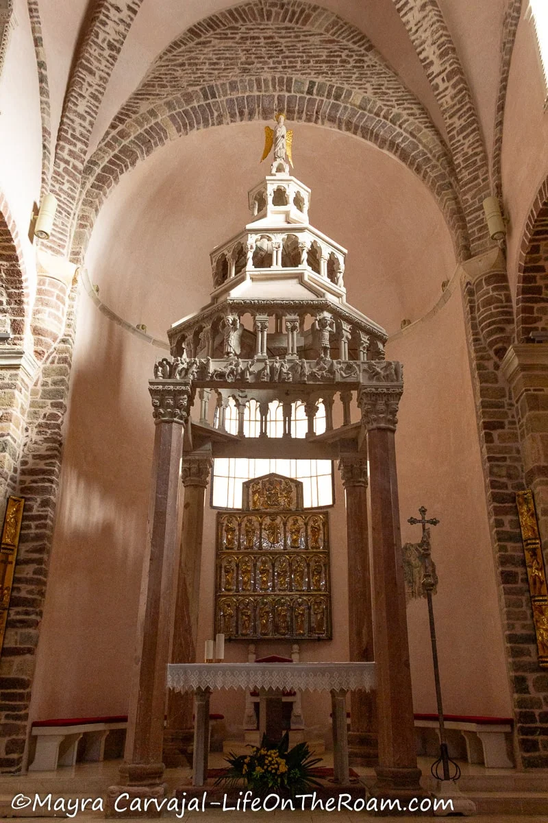 The apse of a church with  an altar and an elaborate backdrop