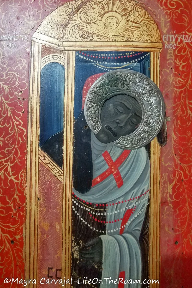 A religious painting with red and gold tones and a risa
