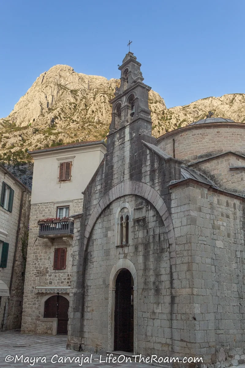 A small church with an arched entrance and a belfry with three bells