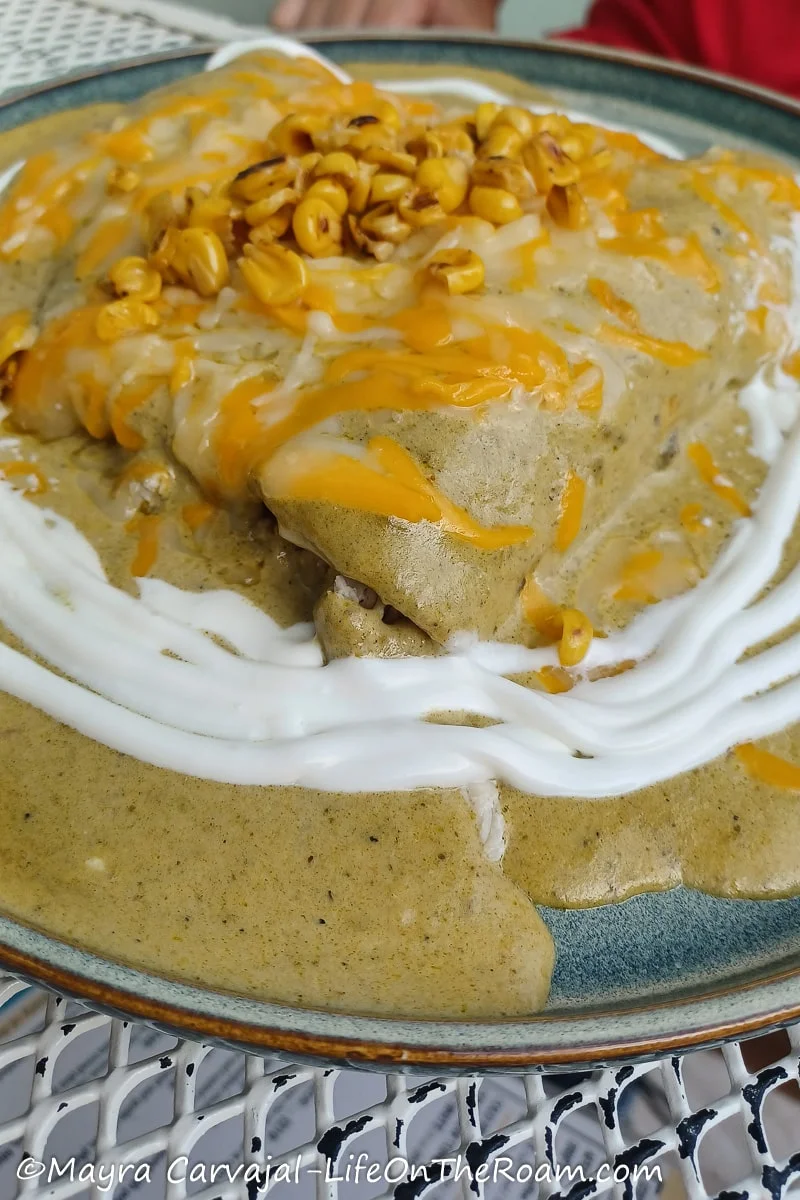 Enchiladas covered in sauce topped with corn