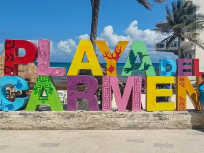 Mayra standing next to the colourful Playa del Carmen letters