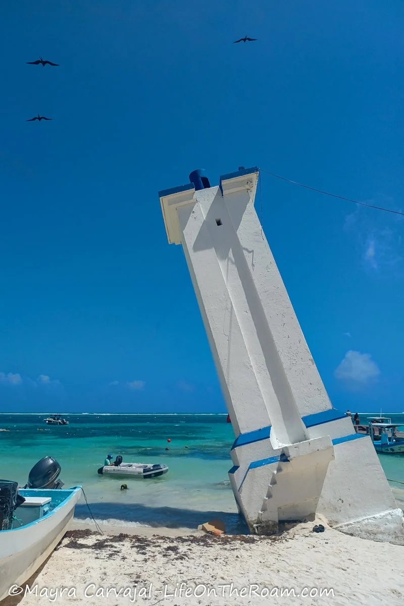 A leaning lighthouse on a beach