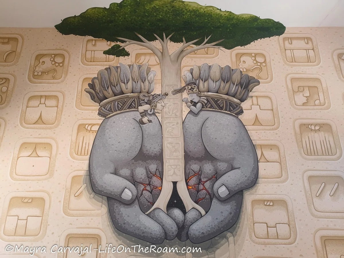 A large mural in earthly tones depicting the Tree of Life of the Mayan culture
