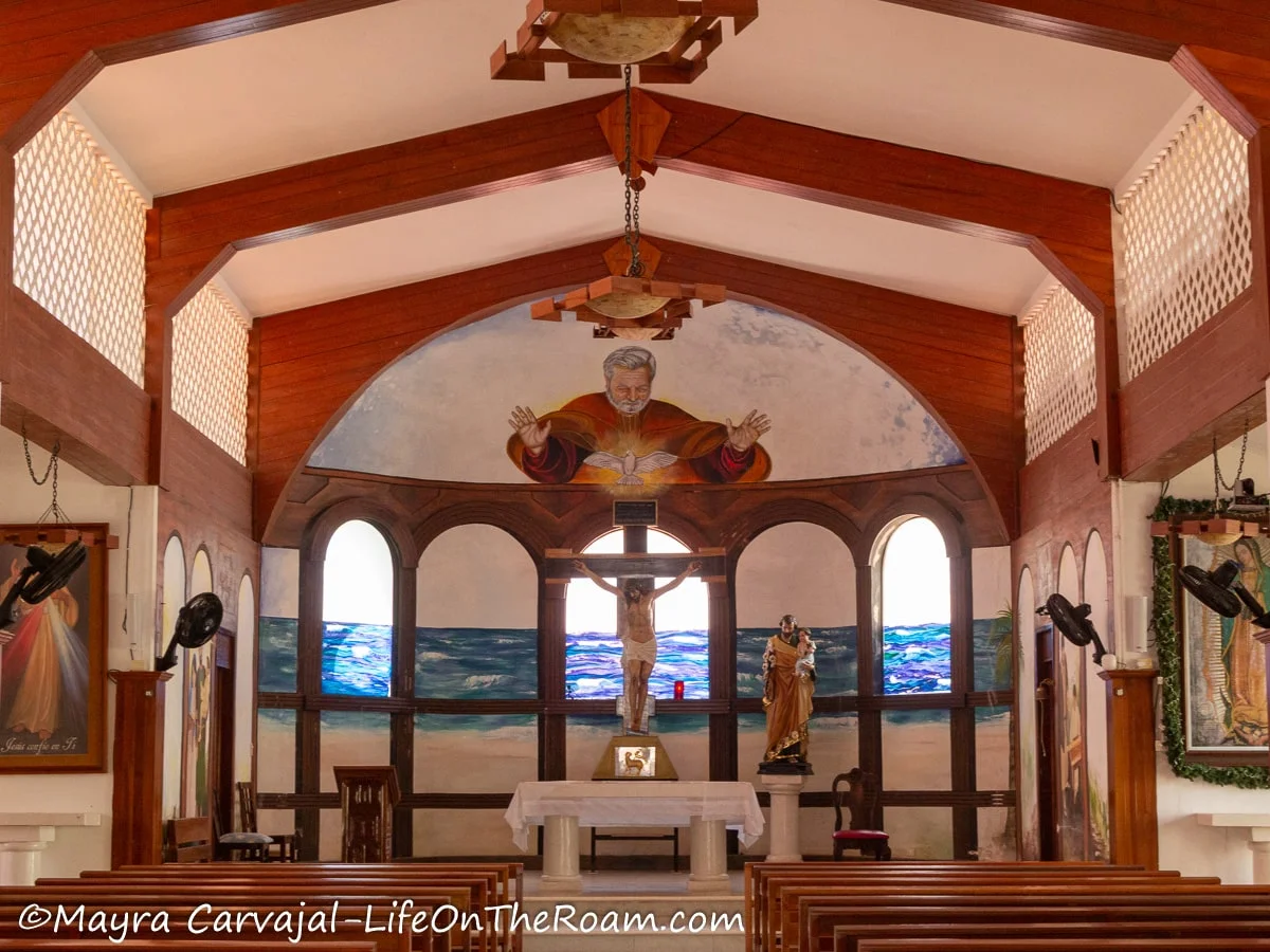 The nave and apse of a church with a mural depicting sea and sand