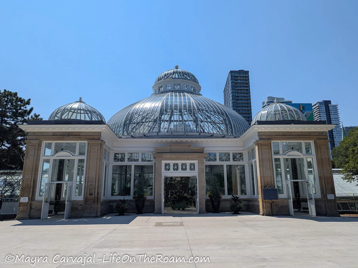 A historic greenhouse with glass ceiling domes in a city park