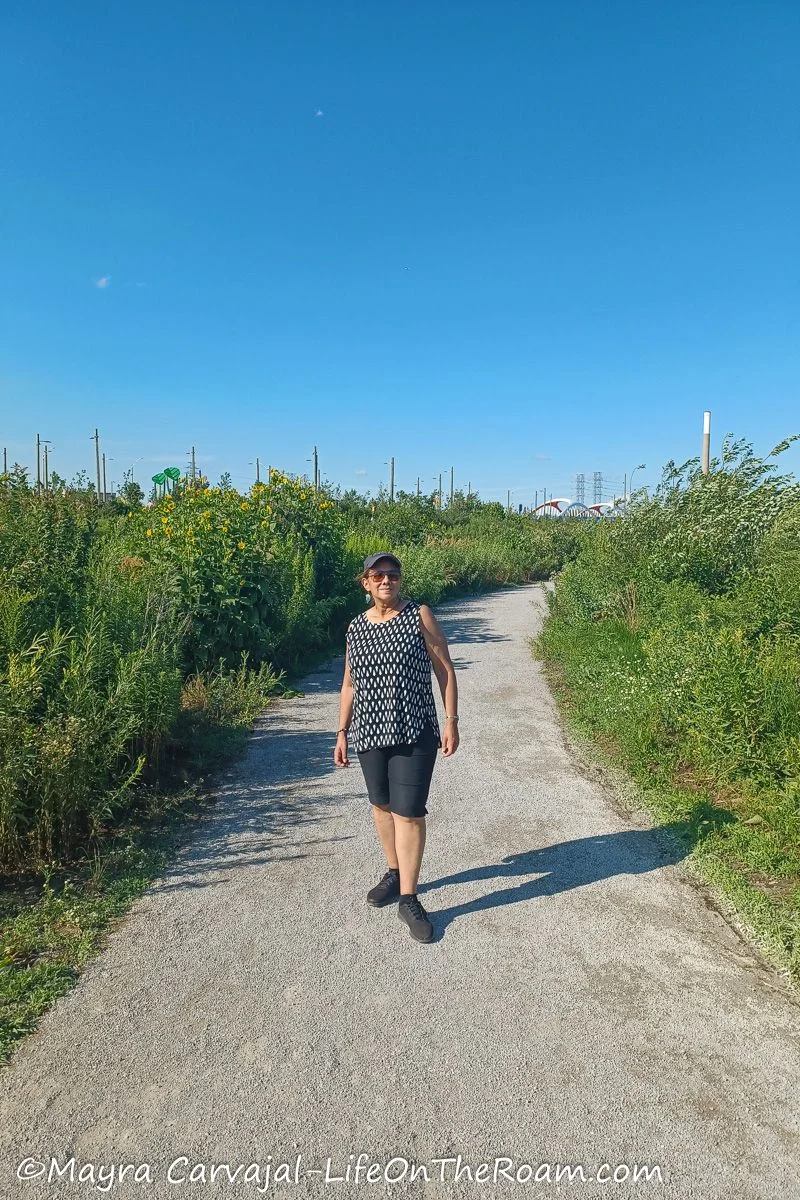 Mayra on a trail flanked by native plants