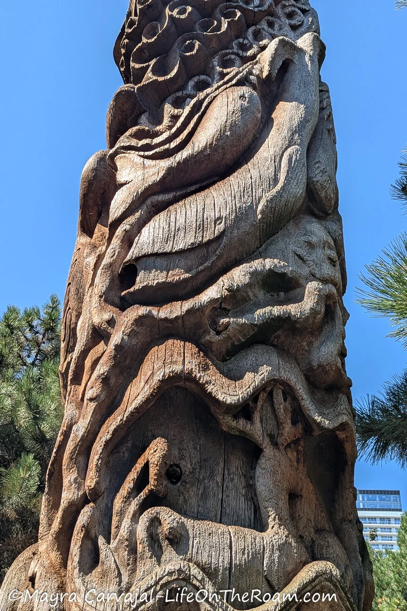 Details of a totem pole with representation of whales, fish, deer and waves