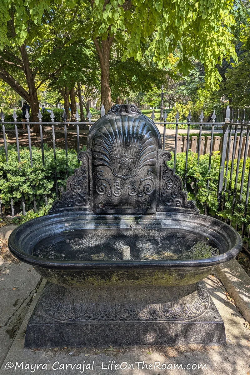 A historic horse fountain in a park