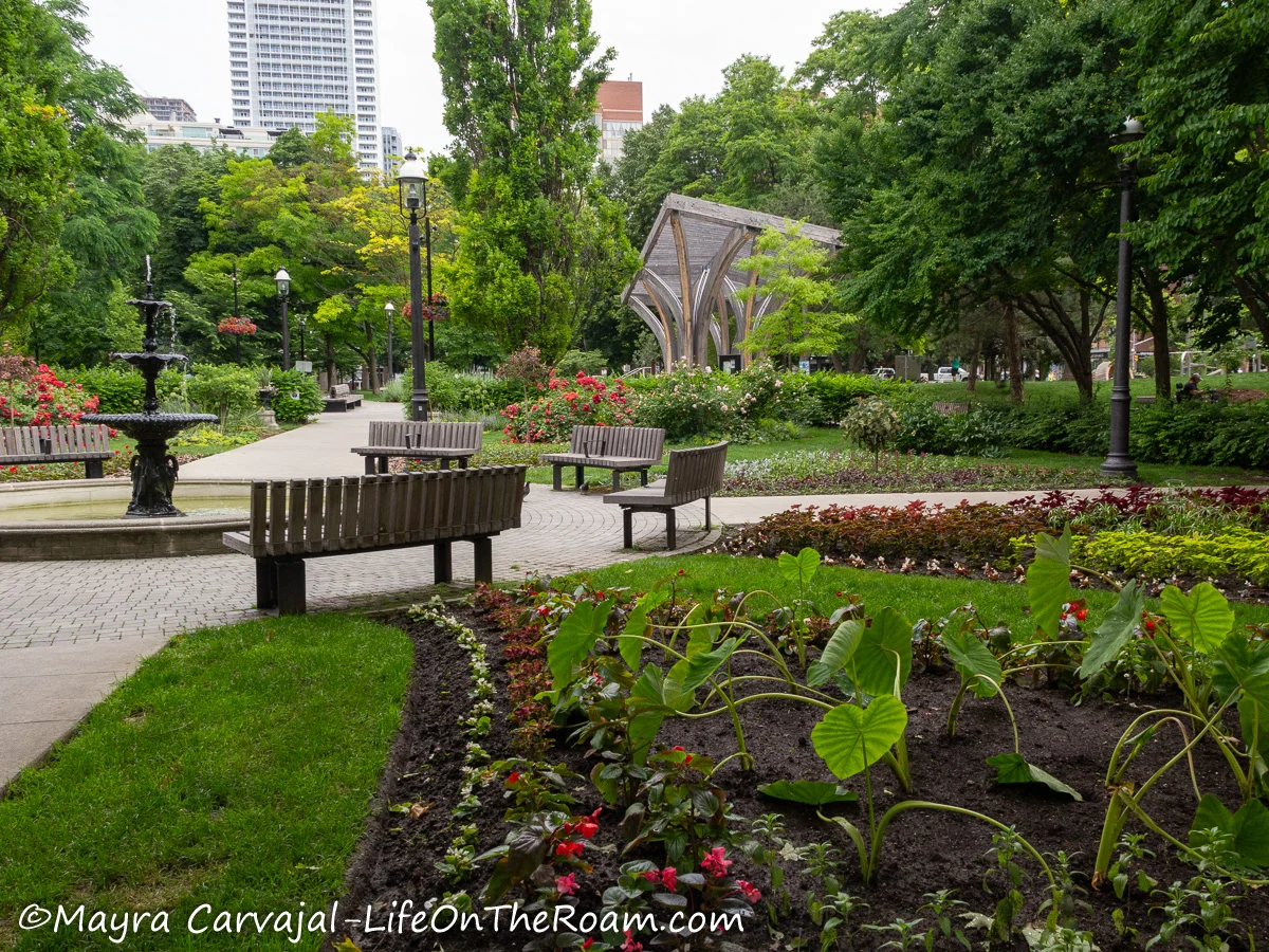 Gardens in an urban park with benches and a pavilion