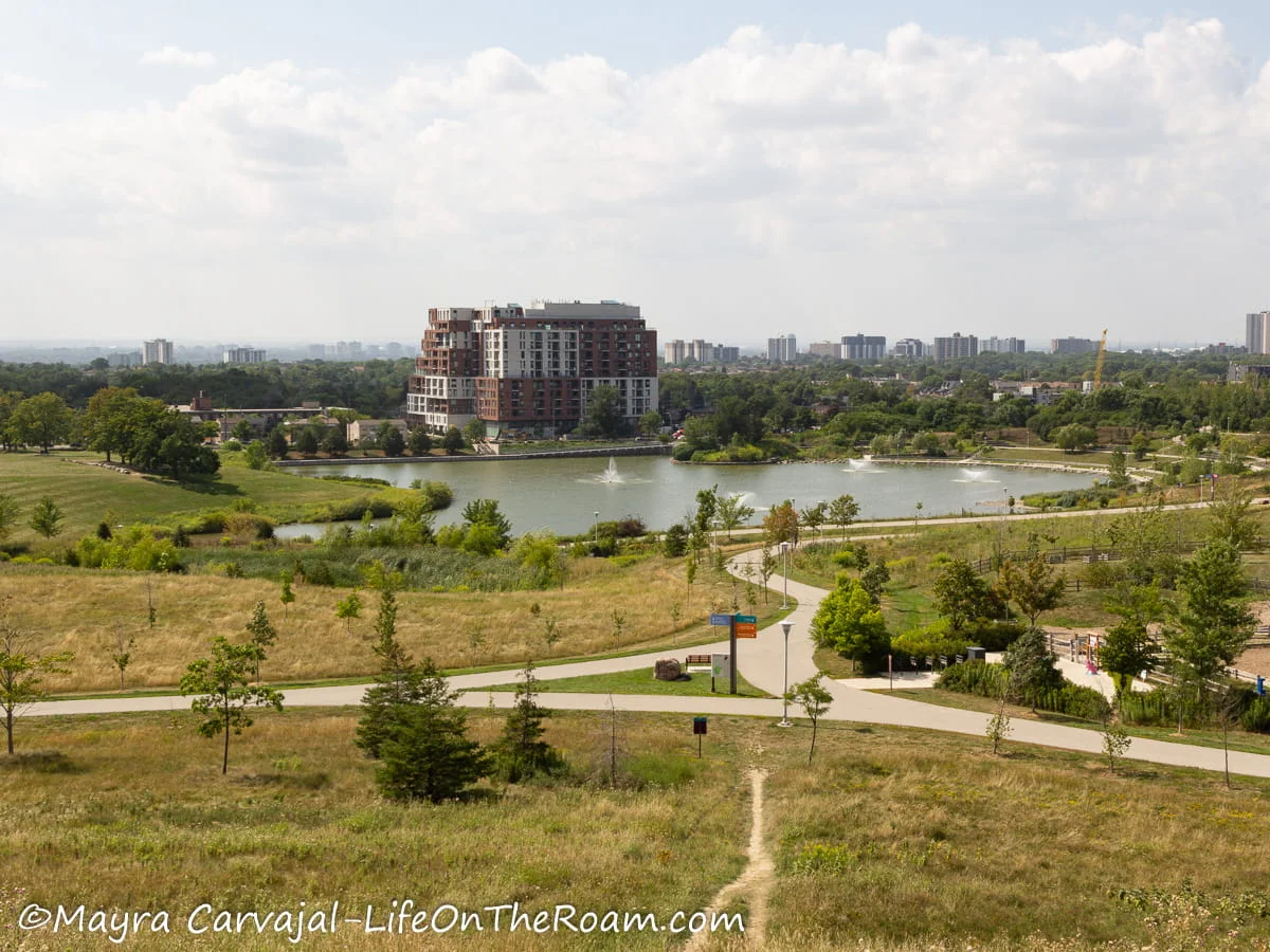 High view of an urban park with a lake surrounded by trees and trails